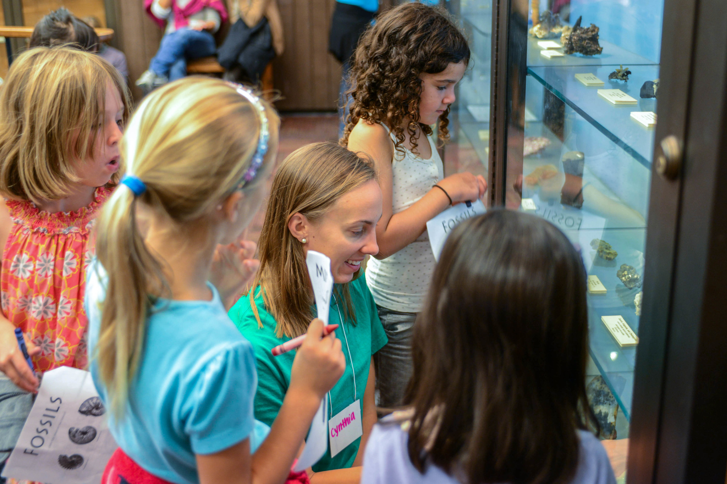 Kids and camp counselor looking at fossils