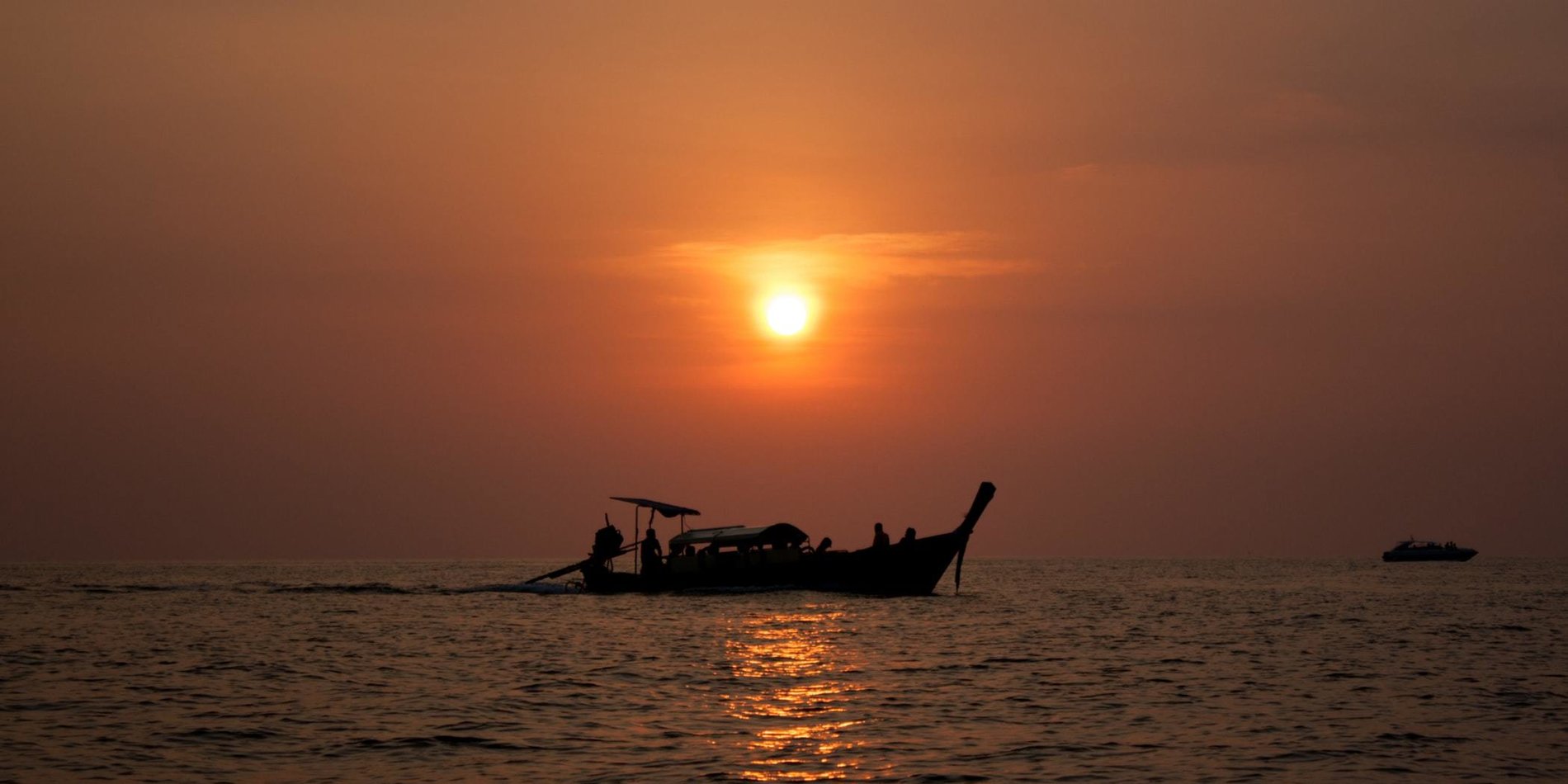 Fishing boat out on the ocean during sunset