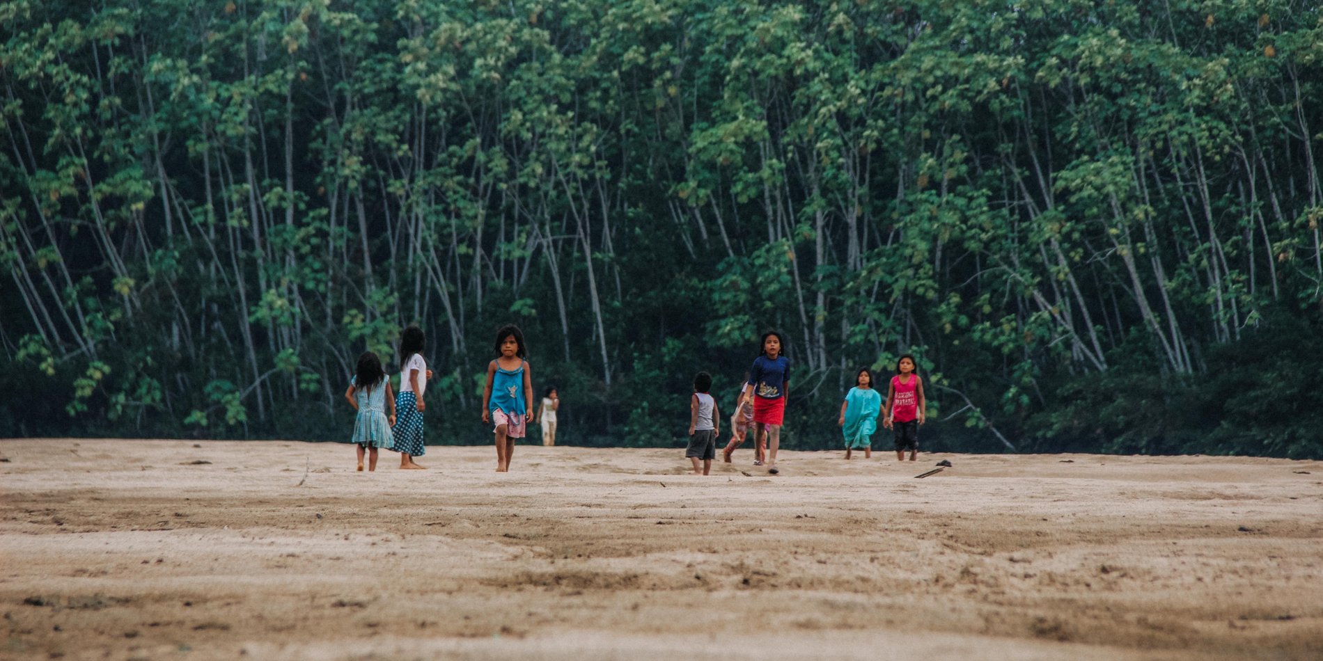 Children walk across deforested area. 