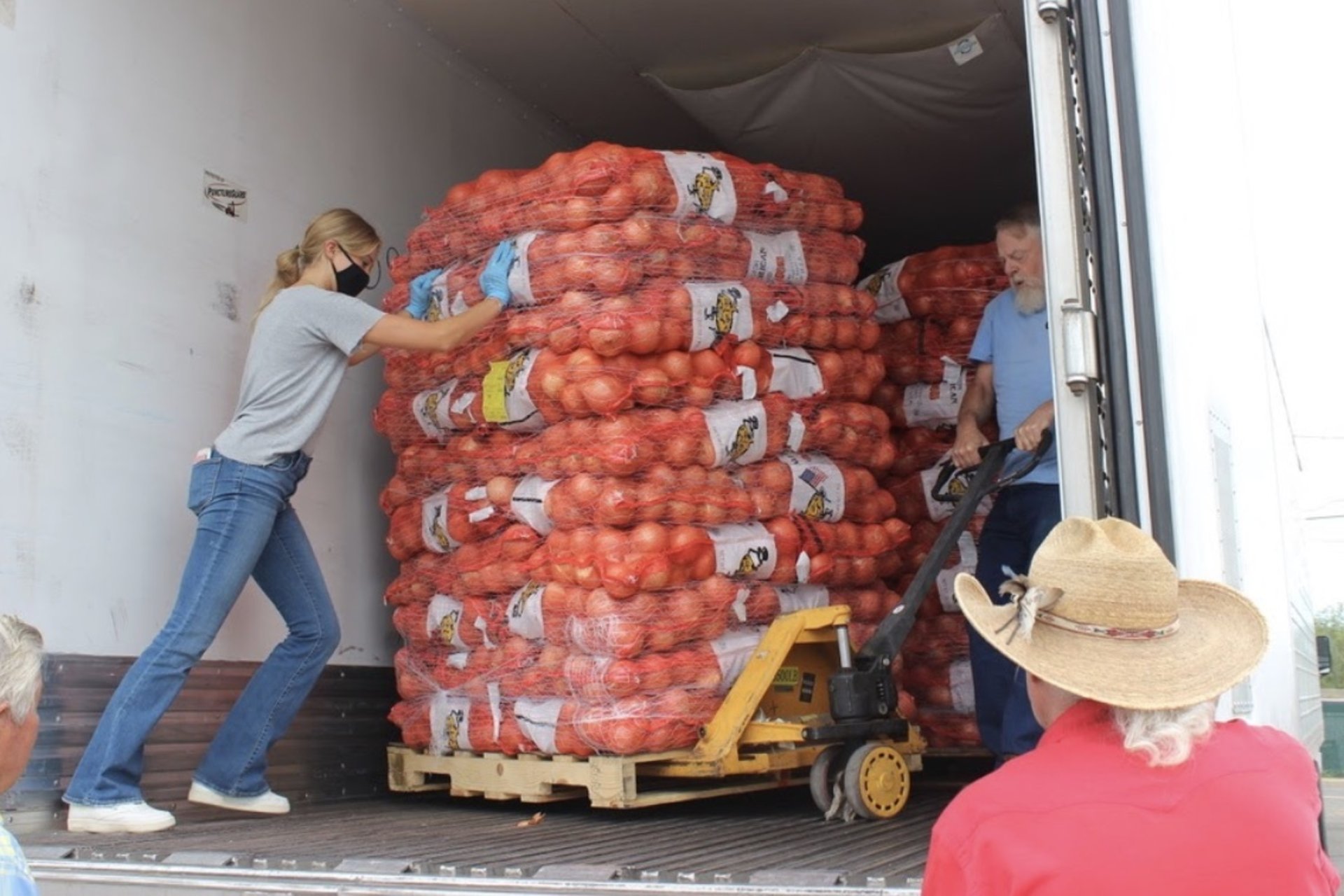 Person pushes pallet of potatoes