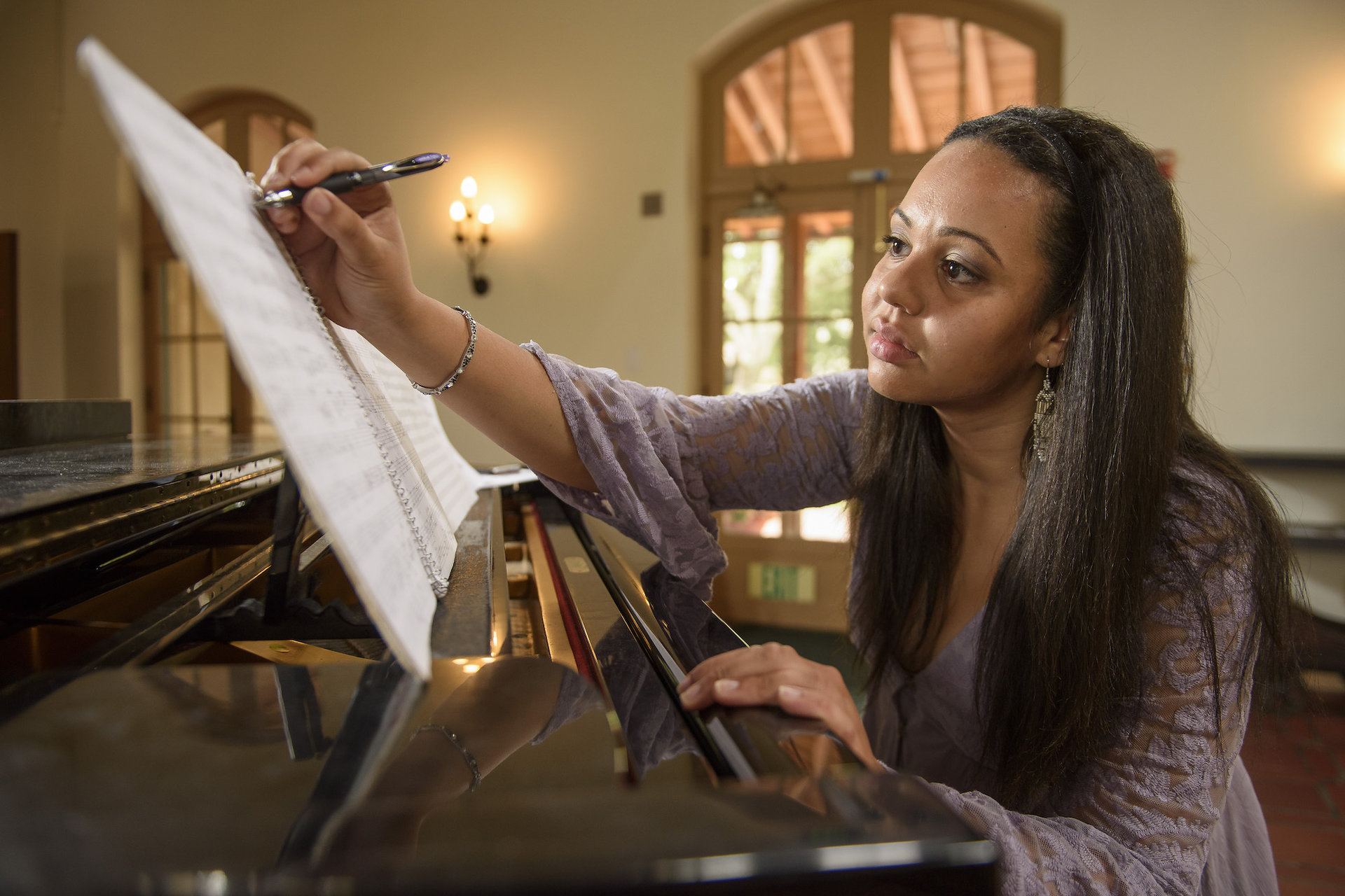 Student writing music on stand.