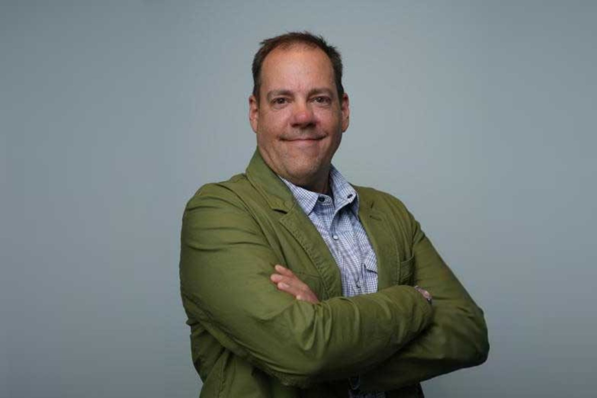 Steve Davis smiling with his arms crossed