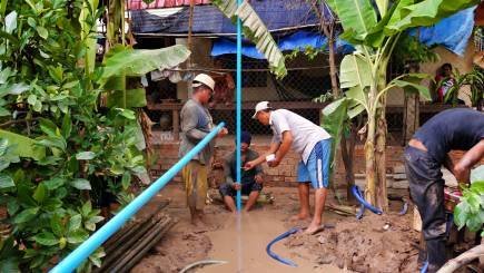 Three men standing around a well