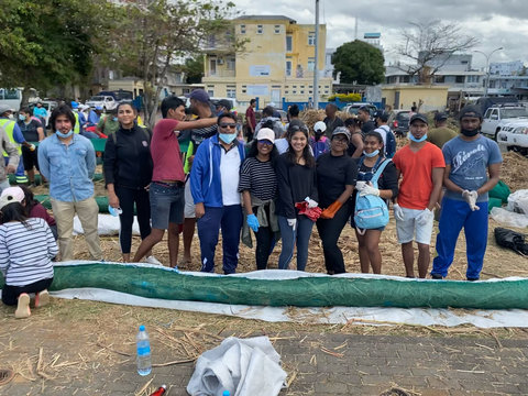 Residents in Mauritius stand behind an oil spill boom