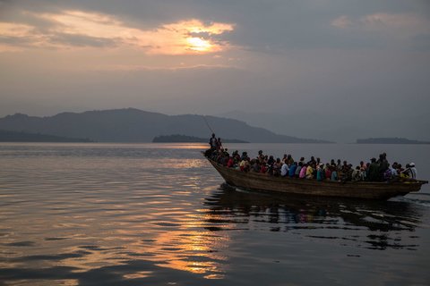 A boat filled with dozens of passengers travels through the water