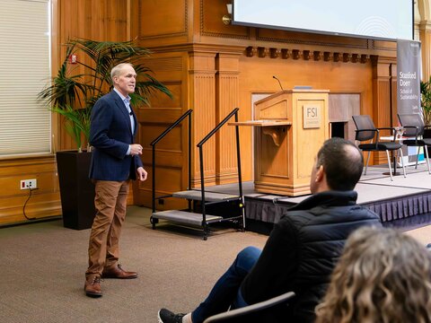 Rob Jackson stands and sings in front of an audience next to the stage