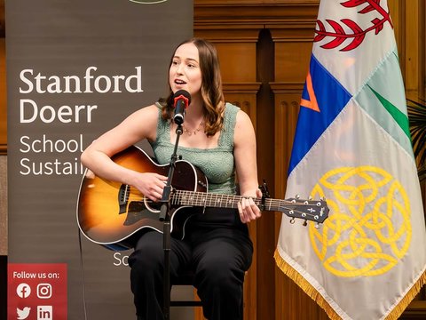 Vivian Leilani Shay singing and playing the guitar on stage