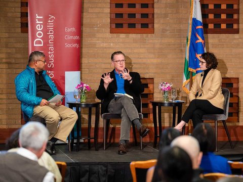 Mitchell Stevens speaking on stage next to Arun Majumdar and Emily Levine