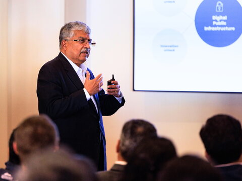 Close-up of Nilekani speaking in front of a slide with the words, Digital Public Infrastructure