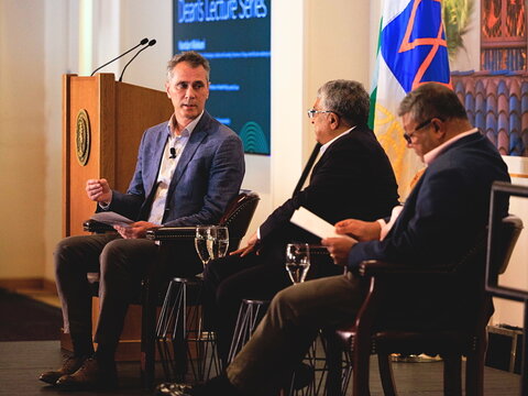 David Studdert speaks next to Nandan Nilekani and Arun Majumdar on stage