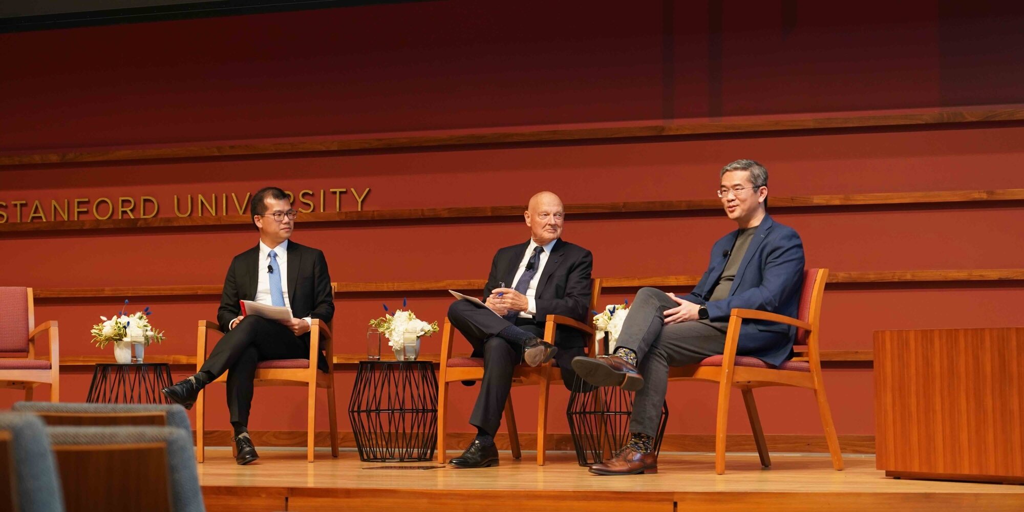 William Chueh, James O Ellis Junior, and Lew Chuen Hong speak on stage